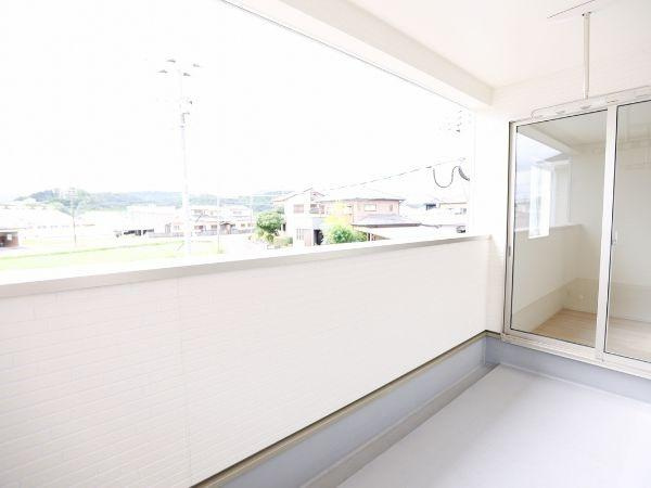 挾間町下市第1-2号棟のバルコニー|明るい光が差し込むバルコニーです。広々としたスペースで使い勝手が良いです。開放的なガラス扉で室内とのつながりも感じられます。外まで続く見晴らしが魅力的です。