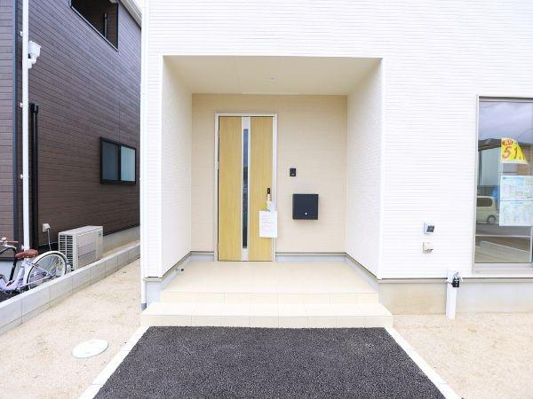 挾間町下市第1-2号棟の玄関|明るい玄関スペースが印象的です。段差が少なく出入りがしやすいデザインです。シンプルで落ち着いた色合いが外観を引き立てています。郵便受けもすっきりと配置されています。