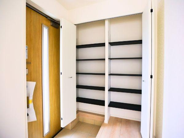 挾間町下市第1-2号棟の玄関|玄関には収納力のあるシューズクローゼットがあり日々の整理整頓もスムーズです。扉付きで見た目もすっきり保てます。木目調のドアが空間に温かみをプラスしています。明るい玄関で毎日の出入りも快適です。