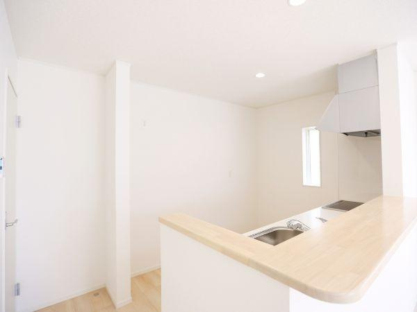 挾間町下市第1-2号棟のキッチン|白を基調とした明るいキッチンです。広々としたカウンターが設置されており開放感があります。シンクや調理スペースも使いやすい配置になっています。小窓があるので自然光も取り入れやすいです。