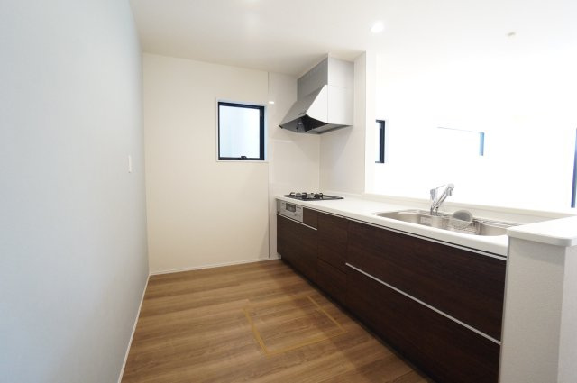 リーブルガーデン常滑市新浜町3丁目第3　1号棟のキッチン|グレーのアクセントクロスと落ち着いたカラーのキッチンはスタイリッシュな対面式システムキッチン♪