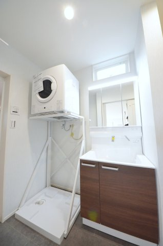 吉島西一丁目の洗面所|清潔感あふれる白を基調としたシャワー付洗面台と洗面室。収納棚もある余裕のスペース。窓もあり明るく通気も良いです。