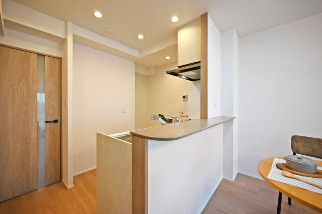 武庫川公園レックスマンションのキッチン|コンロ前袖壁付カウンター造作のキッチンです。上部にはダウンライトを採用し、作業性を確保。