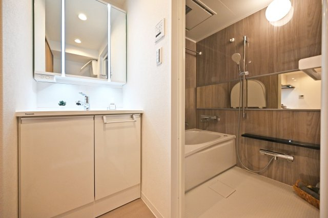 武庫川公園レックスマンションの独立洗面台|3面鏡の明るい洗面化粧台で、毎朝の支度もはかどります。 鏡裏と洗面台横、下にも収納があり、タオルなどの日用品やスキンケア用品などもたくさんしまえてすっきりとした空間を保つことができます。