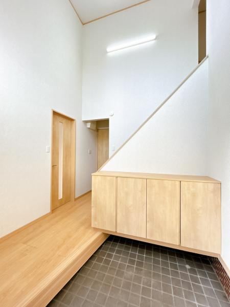 三戸郡五戸町字地蔵岱の玄関|【リフォーム済】吹き抜けのある開放的な玄関ホールです。明るい玄関でお客様をお迎えできます。シューズボックス新品交換、照明新品交換、フロア張替え、壁天井クロス仕上げ等行いました。