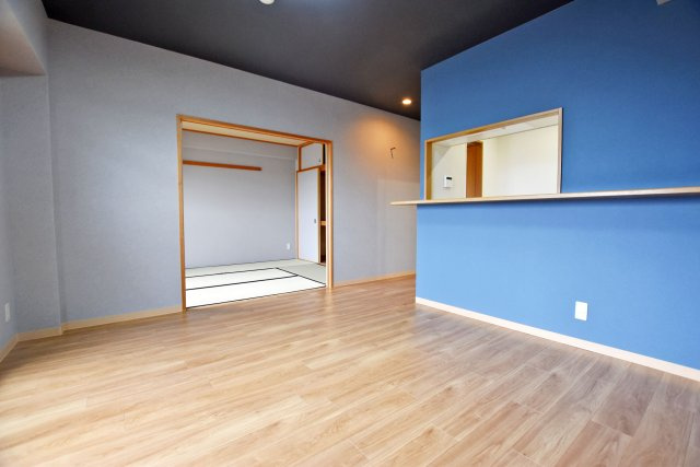 グローバル伊丹昆陽里の居間・リビング|対面式キッチンでダイニングとの距離も近く料理をダイニングに運んだり、片付けたりするのが楽なので家事の時短に繋がります。ブルーのアクセントクロスが映え、おしゃれな空間です。