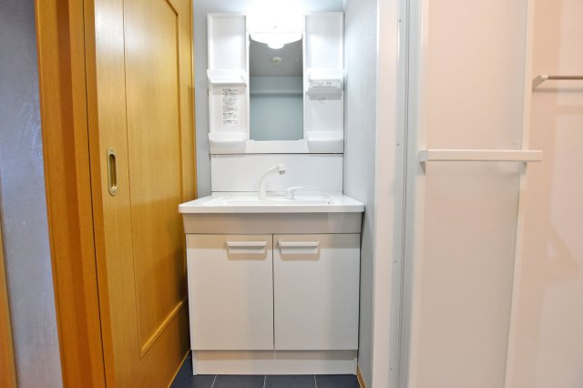 グローバル伊丹昆陽里の独立洗面台|明るい洗面化粧台で、毎朝の支度もはかどります。 鏡横と洗面台下に収納があり、日用品やスキンケア用品等をしまえてすっきりとした空間を保つことができます。