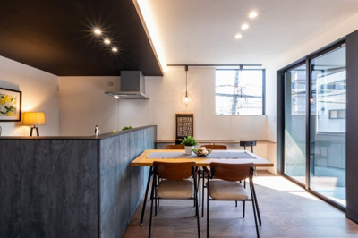 【居間・リビング】 | 城東区鴫野西５丁目新築戸建 | LDK（約18.4帖）：木目の温かみとモダンな無機質さのコントラストが、個性的で居心地の良い空間を創り出しています。