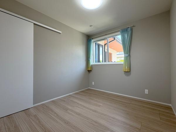 寒田南町二丁目　中古の洋室|シンプルで落ち着いたデザインの洋室です。白い壁と明るい木目調のフローリングが清潔感を与え、全体的に明るい印象を与えています。窓からは外の景色が見え、自然光がしっかりと部屋に差し込んでいます！