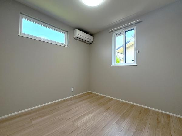 寒田南町二丁目　中古の洋室|明るい木目調のフローリングと、落ち着いたグレーの壁が、落ち着いた雰囲気を醸し出しています。部屋には2つの窓があり、外からの自然光がしっかりと取り込まれ、明るく開放的な印象を与えます♪