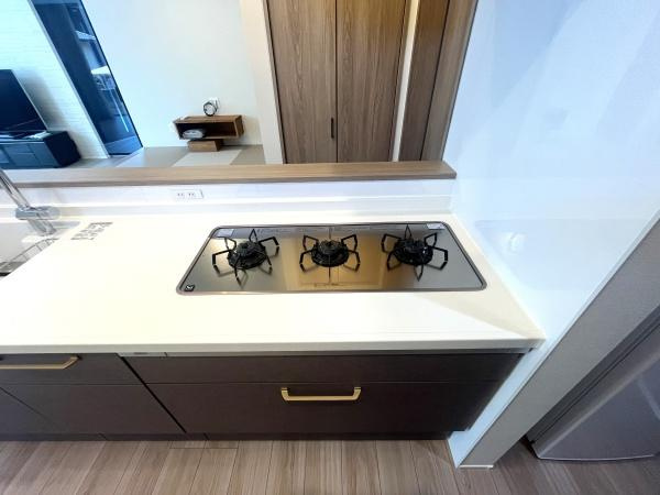 寒田南町二丁目　中古のキッチン|三口コンロは、効率よく料理を進めるための理想的なデザインです。各コンロが均等に配置されており、大きな鍋やフライパンを同時に使っても快適に調理できます！