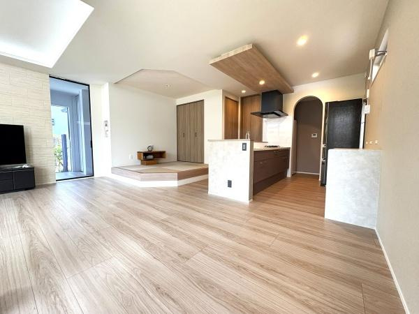 寒田南町二丁目　中古の居間・リビング|温かみのあるフローリングとオープンなキッチンが、家族みんなでゆったり過ごせる空間を作り出しています。さらに、和のテイストを取り入れた小上がりスペースもあり、落ち着いた雰囲気が魅力的です♪