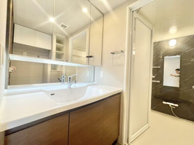 【独立洗面台】 | グランクラッセ上野芝向ヶ丘 | ゆとりの洗面スペースで朝の身支度も快適スムーズに。３面鏡で髪のセットやお化粧もストレスなくこなせ、朝から気分良く通勤通学に向かえそうですね！鏡の裏にはたっぷりと収納スペースを標準装備！