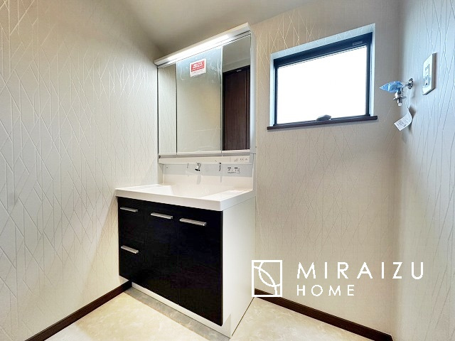 【洗面所】 | 洗濯機置き場と脱衣スペースもしっかりと確保されている洗面室、洗面コーナーは、窓から陽も差し明るく開放的な造りです。家事導線も良いので洗濯物やお湯はりもストレスフリーに毎日家事を楽しめそうです。
