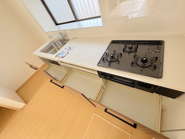 小山市羽川のキッチン|新品のシステムキッチンは収納たっぷりで使い勝手◎。三口コンロで調理もスムーズ！明るい窓があり、気持ちよくお料理ができるスペースになっています。