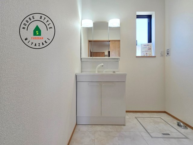 宮崎市生目台西一丁目第1-2棟（A号棟）の内観：施工例|毎日使うものだから清潔な空間を保ちたい水回り。洗面にはそんな願いを解消させてくれる収納アイデアが満載です。三面鏡の裏側にはキャビネットが現れ小物から背の高い物まで収納できます。