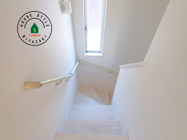 宮崎市生目台西一丁目第1-2棟（A号棟）の内観：施工例|＜手すり付階段＞手すりがないと階段の昇り降りで危険なことはもちろん、壁に手をつきながら歩くことで壁紙が汚れやすくなります。すべての方に快適に昇り降りしていただくため、手すりを設置しました。