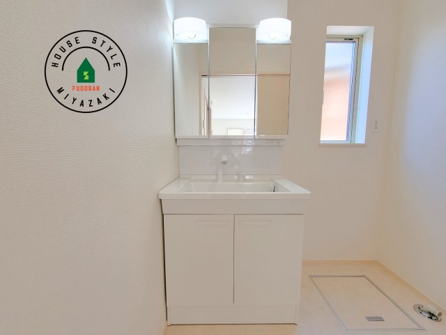 宮崎市生目台西一丁目第1-2棟（B号棟）の内観：施工例|毎日使うものだから清潔な空間を保ちたい水回り。洗面にはそんな願いを解消させてくれる収納アイデアが満載です。三面鏡の裏側にはキャビネットが現れ小物から背の高い物まで収納できます。