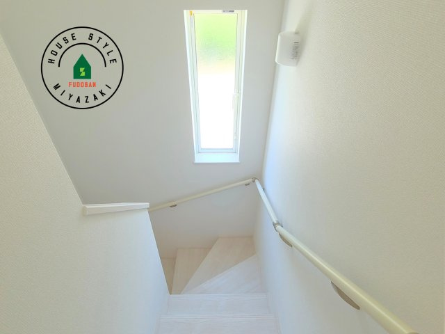 宮崎市生目台西一丁目第1-2棟（B号棟）の内観：施工例|＜手すり付階段＞手すりがないと階段の昇り降りで危険なことはもちろん、壁に手をつきながら歩くことで壁紙が汚れやすくなります。すべての方に快適に昇り降りしていただくため、手すりを設置しました。