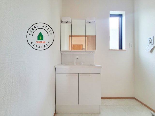 児湯郡北高鍋第1-2棟（B号棟）の独立洗面台|毎日使うものだから清潔な空間を保ちたい水回り。洗面にはそんな願いを解消させてくれる収納アイデアが満載です。三面鏡の裏側にはキャビネットが現れ小物から背の高い物まで収納できます。