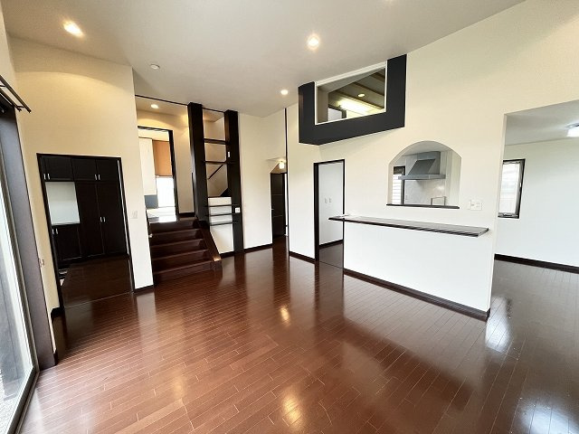 筑西市関本上の居間・リビング|赤いキッチンがアクセント♪南側の大きな窓から陽ざしがたっぷり入る、明るく気持ちの良い19帖の広々空間です◎