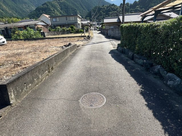 大生院 栗林　売土地の前面道路含む現地写真|西側接道を南向きに撮影。道路から敷地内が見通しやすく、日当たりも確保しやすい接道条件です。ゆとりある道幅ではないものの、車の往来が少ないため、落ち着いて駐車操作ができます。