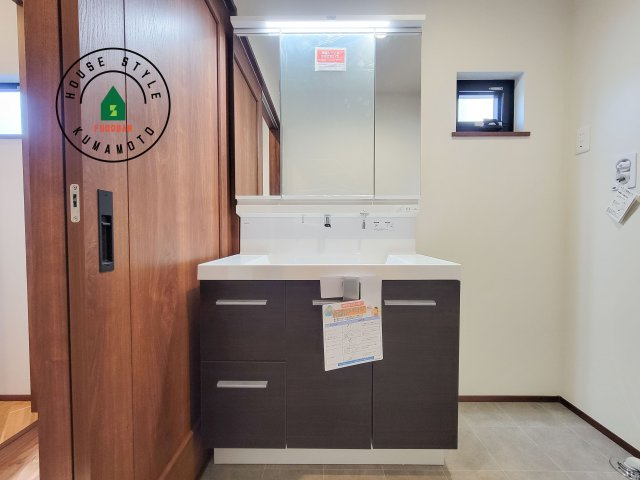 菊池郡大津町室第1-3棟（6号棟）の内観：施工例|毎日使うものだから清潔な空間を保ちたい水回り。洗面にはそんな願いを解消させてくれる収納アイデアが満載です。三面鏡の裏側にはキャビネットが現れ小物から背の高い物まで収納できます。