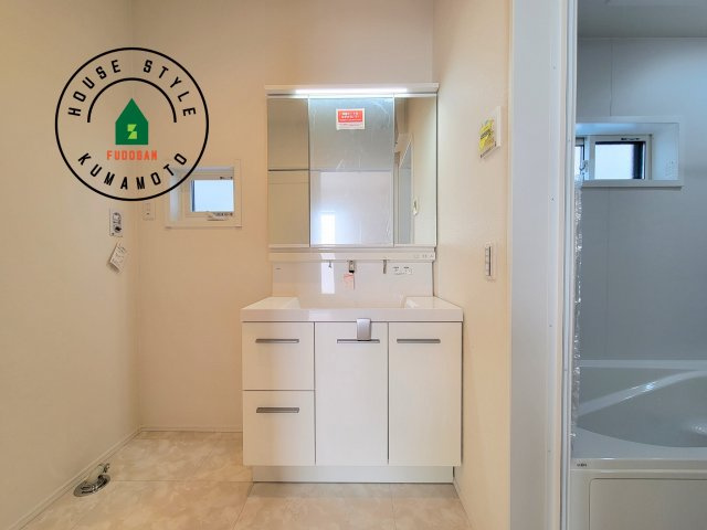 合志市幾久富第1-2棟（5号棟）の内観：施工例|毎日使うものだから清潔な空間を保ちたい水回り。洗面にはそんな願いを解消させてくれる収納アイデアが満載です。三面鏡の裏側にはキャビネットが現れ小物から背の高い物まで収納できます。
