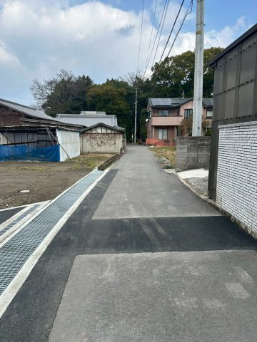 外山町　売土地　3区画の前面道路含む現地写真|東側道路に面した現地は、交通量が少なく小さなお子様がいるご家庭も安心です。平坦な道が続くため、ベビーカーでの散歩や自転車移動も快適。周辺は落ち着いた住宅地で、静かで穏やかな毎日を過ごせる環境です。