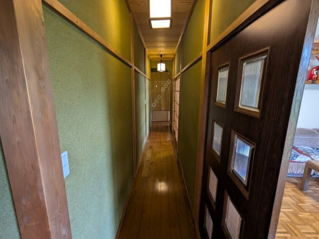 中古戸建　中里見町井ノ下のその他|木のぬくもりと静けさが漂う廊下。温かみのある照明と緑の壁面が、深みのある和の雰囲気を演出します。