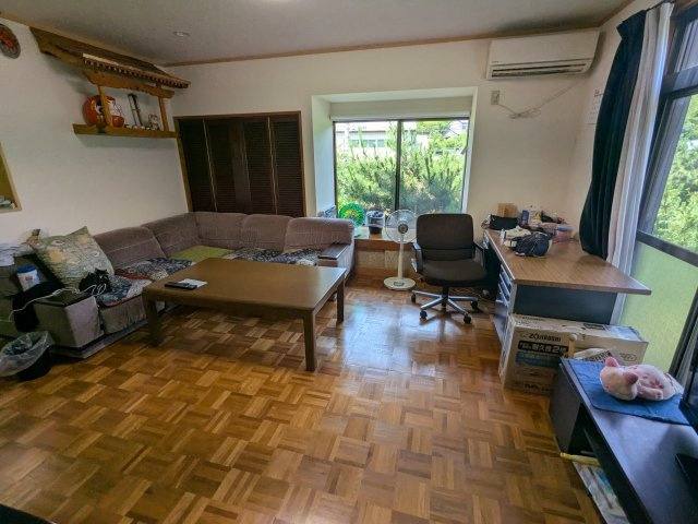 中古戸建　中里見町井ノ下の居間・リビング|大きな窓から明るい光が差し込む広々とした居間。木目調フロアが温かみのある心地よい空間を演出します。
