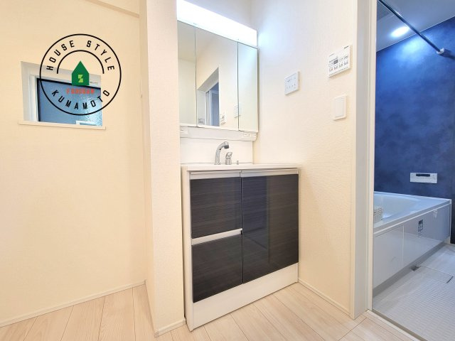 熊本市中央区出水6丁目第3-2棟（2号棟）の内観：施工例|毎日使うものだから清潔な空間を保ちたい水回り。洗面にはそんな願いを解消させてくれる収納アイデアが満載です。三面鏡の裏側にはキャビネットが現れ小物から背の高い物まで収納できます。