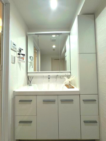 ネオステージ多摩センターの独立洗面台|【洗面化粧台】
カウンタートップが広く、朝の身支度が捗る三面鏡の洗面台です。ミラー裏には、毎日使用する歯ブラシや化粧用品などを収納し、シンク下には掃除用品や大きめのドライヤーなども収納できます。