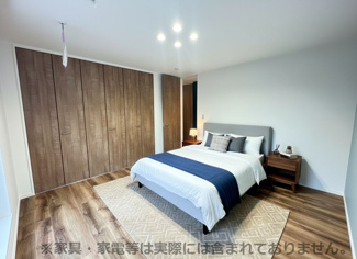 【洋室】 | グランファミーロ清見台　新築戸建　木更津駅 | 2階8帖主寝室。
イメージが沸きやすいように家具を設置してみました。ダブルベッドとサイドテーブルとラグを敷いただけで寛げる空間♪アクセントクロスがおしゃれ♪
【※家具等は実際には含まれておりません。】