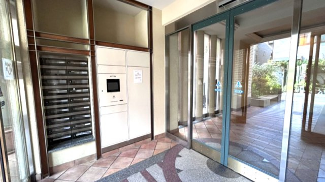セレッソコート甲南山手の設備|オートロックの前に郵便ポストと宅配ボックスが設置されています。