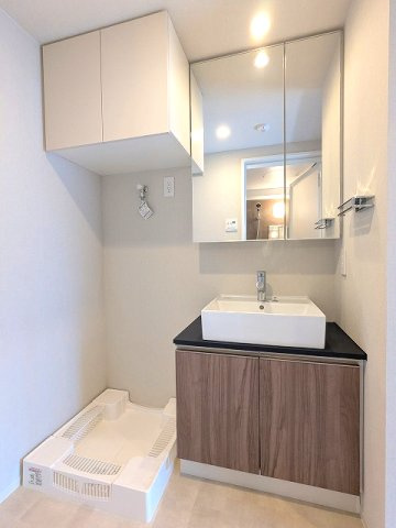 GEO ENT AKIHABARAの洗面所|2面鏡付ハンドシャワー付独立洗面台、タオルラックの上にスマホストレージ付きです、排水口のお手入れしやすく手前中央に配置し、足高の防水パンです