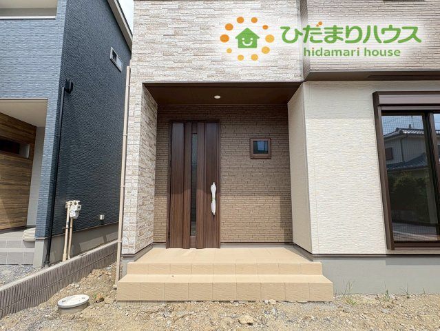 熊谷市上之　第9期　分譲一戸建て　ワイウッドコート　02のエントランス|ご家族やお客様を温かく迎え入れる落ち着いた雰囲気の玄関ポーチ! 木目調の上質なデザインドアが印象的で、雨濡れを防ぐ屋根構造も備わっているため毎日の出入りがとても快適に行えます。