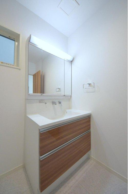 田方2丁目の洗面所|清潔感あふれる白を基調としたシャワー付洗面台と洗面室。幹太くん+収納棚もある余裕のスペース。窓もあり明るく通気も良いです。