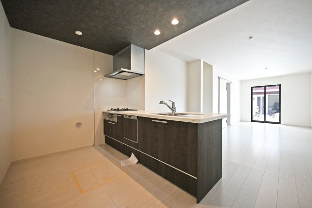 テラシエ下坂部2丁目新築一戸建て全3区画│4LDK+駐車2台可(車種制限有)のキッチン|1階LDKをキッチン越しに撮影した現地内観写真です。 広くて使いやすいキッチンは折り下げ天井を採用しており、 オシャレな空間に仕上がりました。