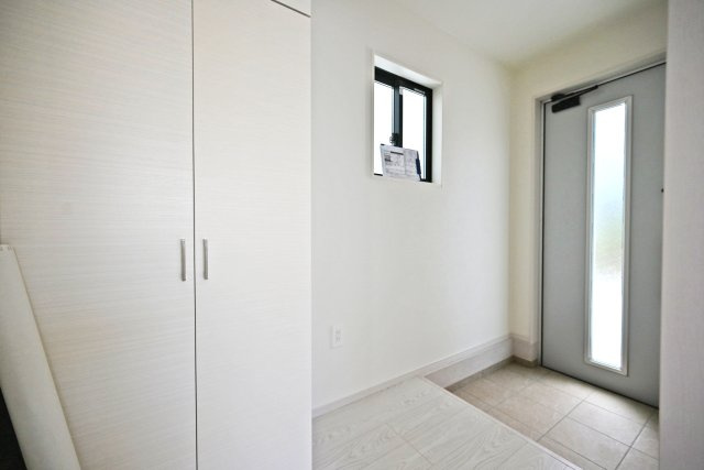 テラシエ下坂部2丁目新築一戸建て全3区画│4LDK+駐車2台可(車種制限有)の玄関|1階玄関をホール側から撮影した内観写真です。 シンプルな玄関扉にシューズボックス、小窓を配置したオーソドックスな玄関です。