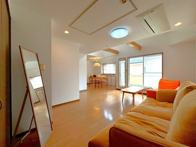 西片2丁目の邸宅の居間・リビング|開放的な吹抜けと日当たりの良いワイドバルコニーから心地よい風が注ぐＬＤＫ（約17.2帖）。スッキリとした天井埋め込み式エアコンと吹抜けのシーリングファンで快適な空間が創造されています。