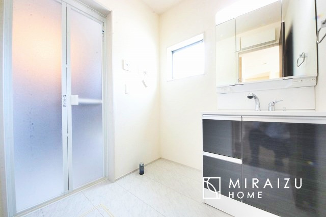 【洗面所】 | 洗濯機置き場と脱衣スペースもしっかりと確保されている洗面室、洗面コーナーは、窓から陽も差し明るく開放的な造りです。家事導線も良いので洗濯物やお湯はりもストレスフリーに毎日家事を楽しめそうです。