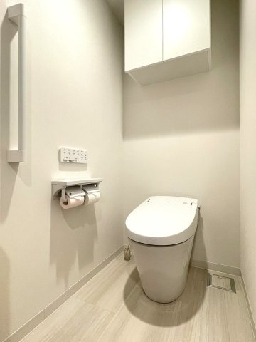 アルファスマート西条助実のトイレ|トイレをすっきりと魅せるタンクレストイレです。吊戸棚収納もついています。