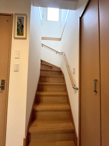 松戸市上矢切戸建の内装|上部の窓から自然光が差し込む明るい階段。手すり付きでお子様やご年配の方にも安心してご利用いただけます。
