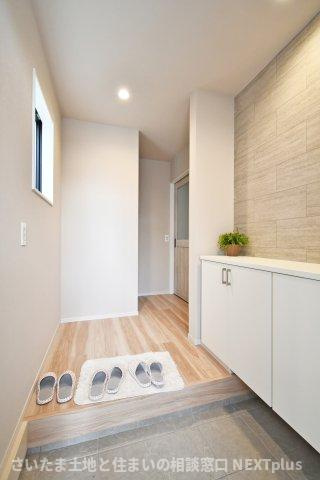 久喜市本町10期全3棟　1号棟の玄関|玄関ドアの正面には壁と収納が設置されておりますので、急な訪問で玄関を開けた際にも室内が見えない設計です！窓もありますので、玄関も外からの光が差し込みます。柔らかい色味で暖かく家族を出迎えてくれます。