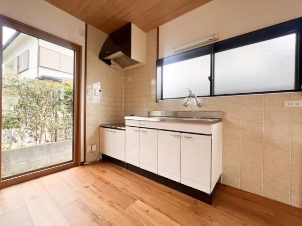 上白木　中古のキッチン|窓からの自然光が明るいキッチンです。シンプルなデザインで収納スペースが豊富に確保されています。