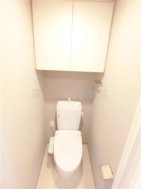 クレストコート池上のトイレ|吊戸棚とカウンター温水洗浄便座付きのトイレ　