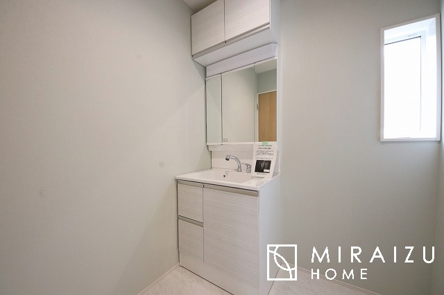 【洗面所】 | 洗濯機置き場と脱衣スペースもしっかりと確保されている洗面室、洗面コーナーは、窓から陽も差し明るく開放的な造りです。家事導線も良いので洗濯物やお湯はりもストレスフリーに毎日家事を楽しめそうです。
