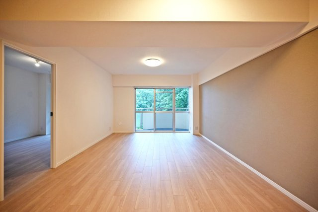 シーアイマンション第2甲陽園の居間・リビング|ダイニングからリビングに向かって撮影した内観写真です。奥右側にテレビボードを置く配置関係で、対面式キッチンでもあるため調理中もご家族の顔が見渡せるコミュニケーションリビングです。