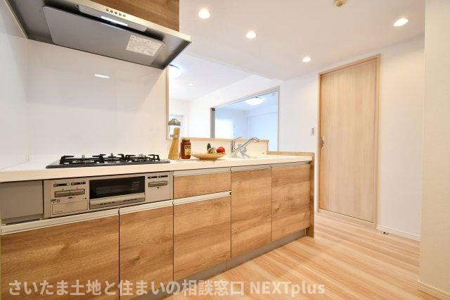 コスモ浦和ガーデンフォルムのキッチン|木目調が温かい雰囲気のキッチンスペースは、L字型で独立した空間になっております。バリケードをつけることで、お子様を刃物や火の元へ近づかせることなく、安心安全にお料理を作ることができます！